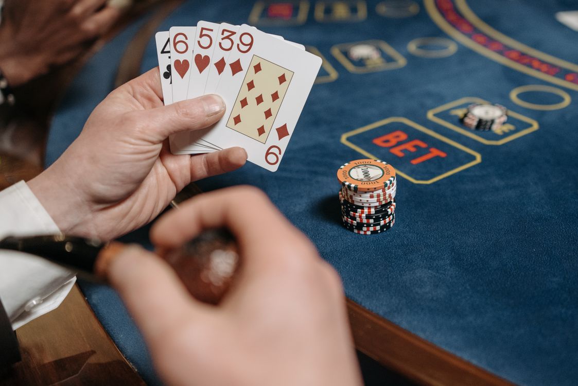 Pemain memegang kartu di meja poker kasino